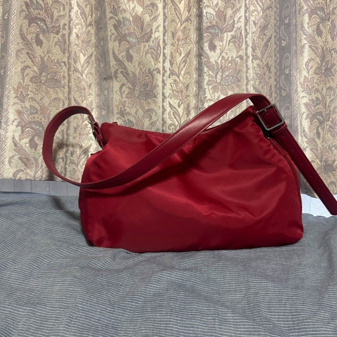 Red Nylon Shoulder Bag with Leather Straps (Category: Shoulder Bags) located in Manila. Submitted by tokyo_thv (Listing ID 1462434515, Image 2). Description: - Red nylon shoulder bag - Genuine leather straps - Silver-tone hardware - Adjustable strap with buckle - Soft, slouchy silhouette - Spacious interior - Ideal for everyday carry.