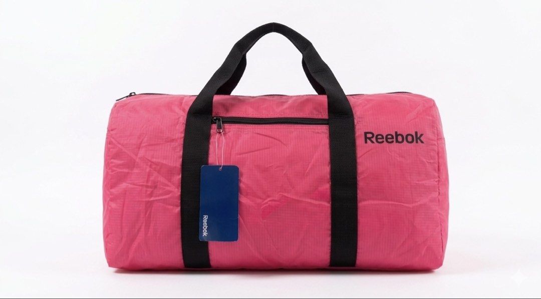 Reebok Pink Duffel Bag (Category: Cross-body Bags) located in Caloocan City. Submitted by safewind.d918ef (Listing ID 1462275354, Image 1). Description: - Pink Reebok duffel bag - Features a front zip pocket - Two comfortable carry handles - Includes original Reebok tag - Ideal for gym sessions or travel - Lightweight and easy to transport.