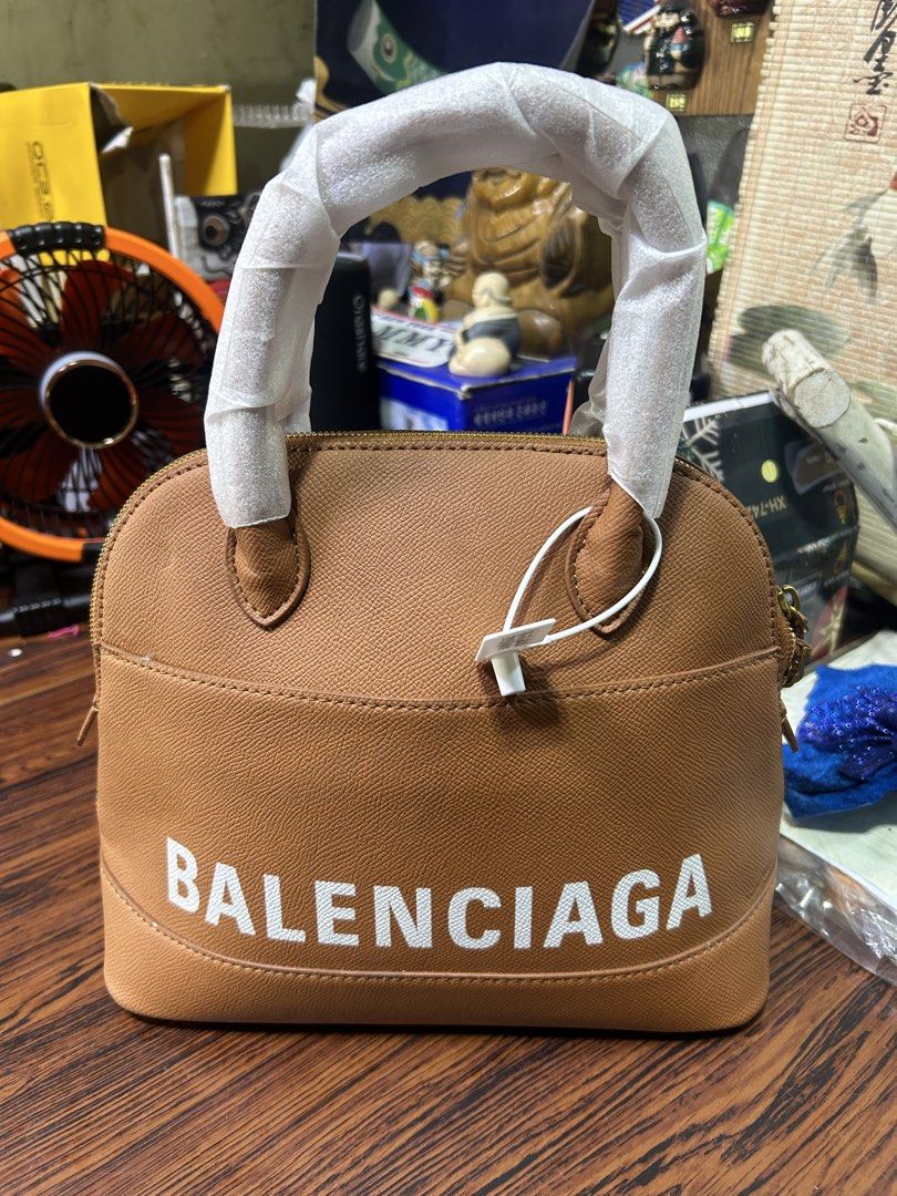 Replica Balenciaga Brown Leather Dome Handbag (Category: Luxury Bags & Wallets) located in Manila. Submitted by starbalesukandjapansurplus (Listing ID 1462437140, Image 1). Description: - Genuine brown leather dome handbag - Authentic Balenciaga logo - Secure gold zipper closure - Interior zippered pocket for essentials - Handles still have protective plastic wrap - Spotless interior condition - Ideal for everyday carry.