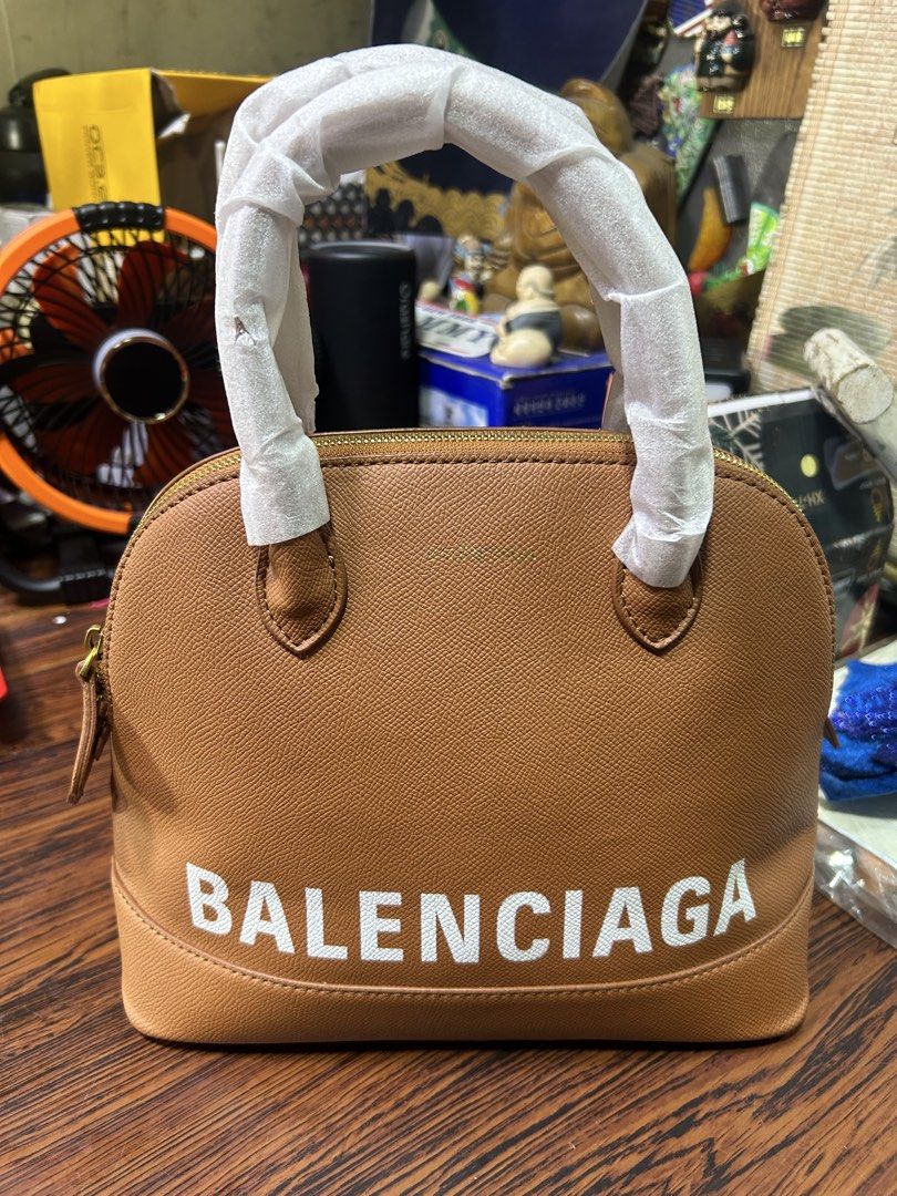 Replica Balenciaga Brown Leather Dome Handbag (Category: Luxury Bags & Wallets) located in Manila. Submitted by starbalesukandjapansurplus (Listing ID 1462437140, Image 3). Description: - Genuine brown leather dome handbag - Authentic Balenciaga logo - Secure gold zipper closure - Interior zippered pocket for essentials - Handles still have protective plastic wrap - Spotless interior condition - Ideal for everyday carry.