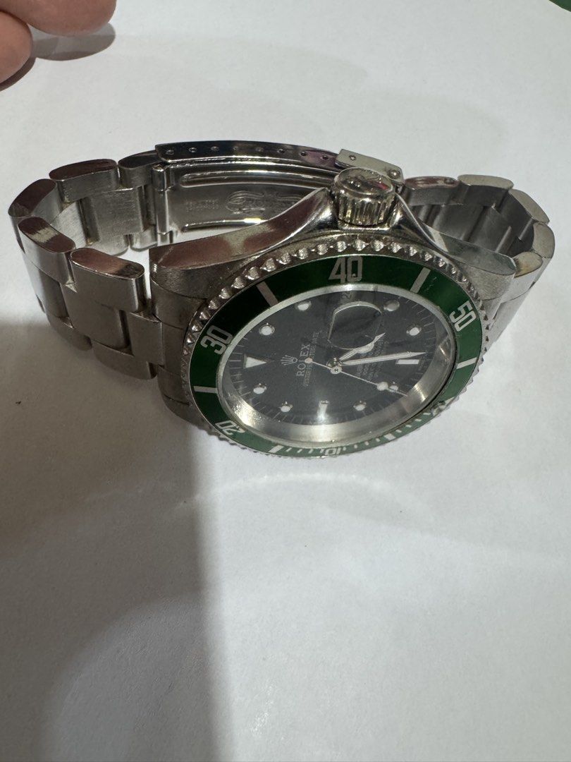Rolex Submariner Date Green Bezel Automatic Men's Watch (Category: Luxury Watches) located in Manila. Submitted by wildbear.e10374 (Listing ID 1462364423, Image 2). Description: - Rolex Oyster Perpetual Date Submariner - Black dial with iconic green rotating bezel - Durable stainless steel Oyster bracelet - Reliable automatic movement - Water resistant up to 300m (1000ft) - Shows some signs of wear on bezel and bracelet, adding to its character -