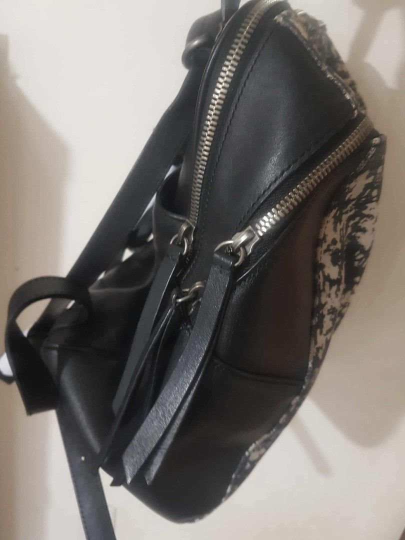 Rouge & lounge Backpack (Category: Luxury Bags & Wallets) located in Marilao. Submitted by joycehart (Listing ID 1462287697, Image 2). Description: - Eye-catching black and white splatter print - Genuine black leather trim - Secure zipper closure - Comfortable top handles - Surprisingly spacious interior - Ideal for everyday errands and style.