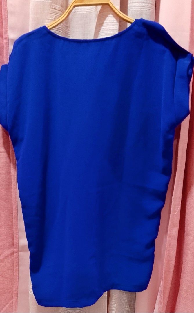 Royal blue tops (Category: Blouses) located in Cabanatuan. Submitted by miss.maia (Listing ID 1462423088, Image 2). Description: This royal blue short-sleeve top from the brand Sybaris features a clean, boat-neck collar design with extended shoulder/cap sleeves. It provides a simple, modern look perfect for both casual everyday wear and business-casual layering..