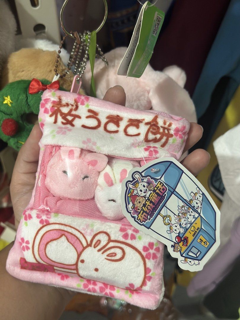 Sakura Bunny Plush Pouch with Mini Plushies (Category: Plushies & Soft Toys) located in Baguio. Submitted by cherylcaps95 (Listing ID 1462341533, Image 1). Description: - Adorable pink pouch featuring sakura and bunny designs. - Comes with two (2) soft and fluffy bunny plushies inside. - Includes a convenient keychain attachment. - Features a secure zipper closure. - Ideal for storing small essentials or as a charming accessory..