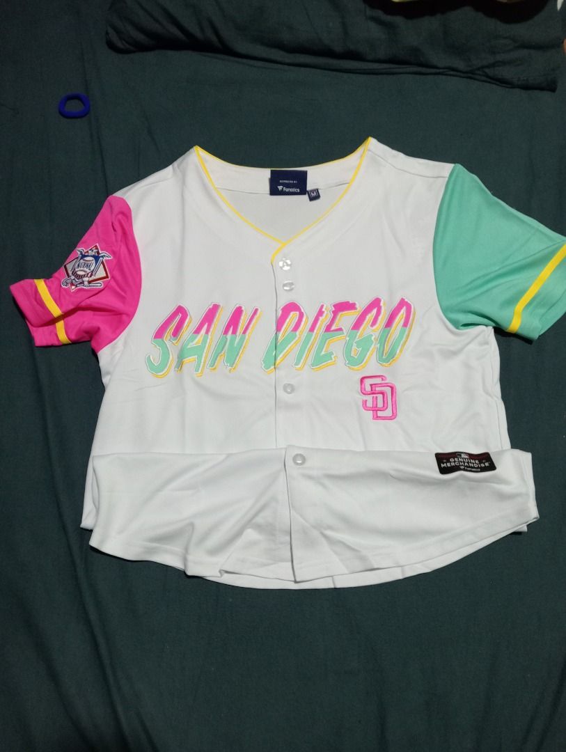 San Diego Padres Baseball Jersey M (Category: Tshirts & Polo Shirts ) located in Caloocan City. Submitted by yazzielux (Listing ID 1462432277, Image 2). Description: - Authentic Fanatics San Diego Padres Baseball Jersey - Size: Medium (M) - Color: White body with striking pink and teal sleeves - Design: 'San Diego' text across the chest with the iconic Padres logo - Style: Classic button-up front.