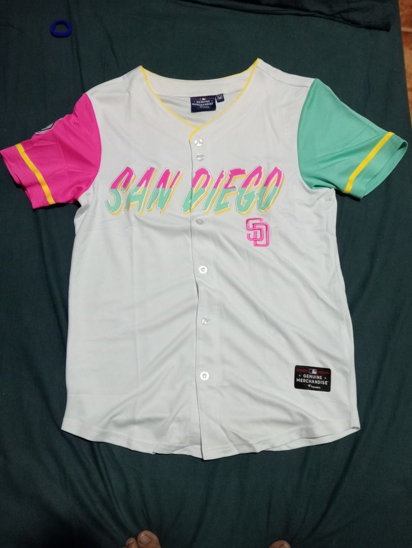 San Diego Padres Baseball Jersey M (Category: Tshirts & Polo Shirts ) located in Caloocan City. Submitted by yazzielux (Listing ID 1462432277, Image 1). Description: - Authentic Fanatics San Diego Padres Baseball Jersey - Size: Medium (M) - Color: White body with striking pink and teal sleeves - Design: 'San Diego' text across the chest with the iconic Padres logo - Style: Classic button-up front.