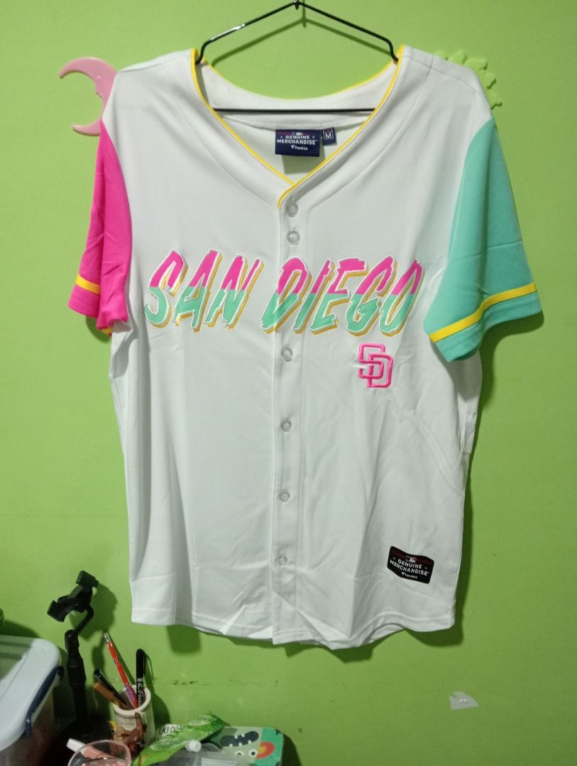 San Diego Padres Baseball Jersey M (Category: Tshirts & Polo Shirts ) located in Caloocan City. Submitted by yazzielux (Listing ID 1462432277, Image 3). Description: - Authentic Fanatics San Diego Padres Baseball Jersey - Size: Medium (M) - Color: White body with striking pink and teal sleeves - Design: 'San Diego' text across the chest with the iconic Padres logo - Style: Classic button-up front.