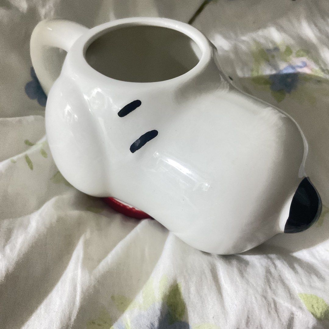 Snoopy Ceramic Mug (Category: Coffee & Tea Tableware) located in Naga. Submitted by asrid.32 (Listing ID 1462363087, Image 2). Description: - Adorable Snoopy-shaped mug - Classic white ceramic with black eyes and nose - Charming red detail at the base - Ideal for your morning coffee or evening tea - A must-have for any Snoopy enthusiast - Adds a fun touch to your kitchenware.