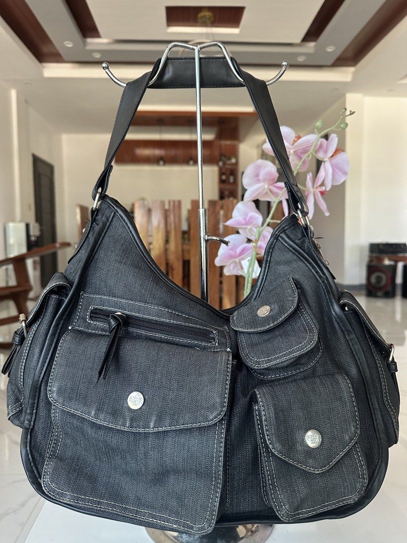 Sophie Paris Denim Hobo Bag (Category: Luxury Bags & Wallets) located in Manila. Submitted by goldenhorse-dafc (Listing ID 1462282609, Image 2). Description: - Dark wash denim hobo bag by Sophie Paris - Multiple pockets on front and sides for organization - Secure zipper closure for the main compartment - Durable leather straps and trim - Spacious interior, ideal for everyday essentials.