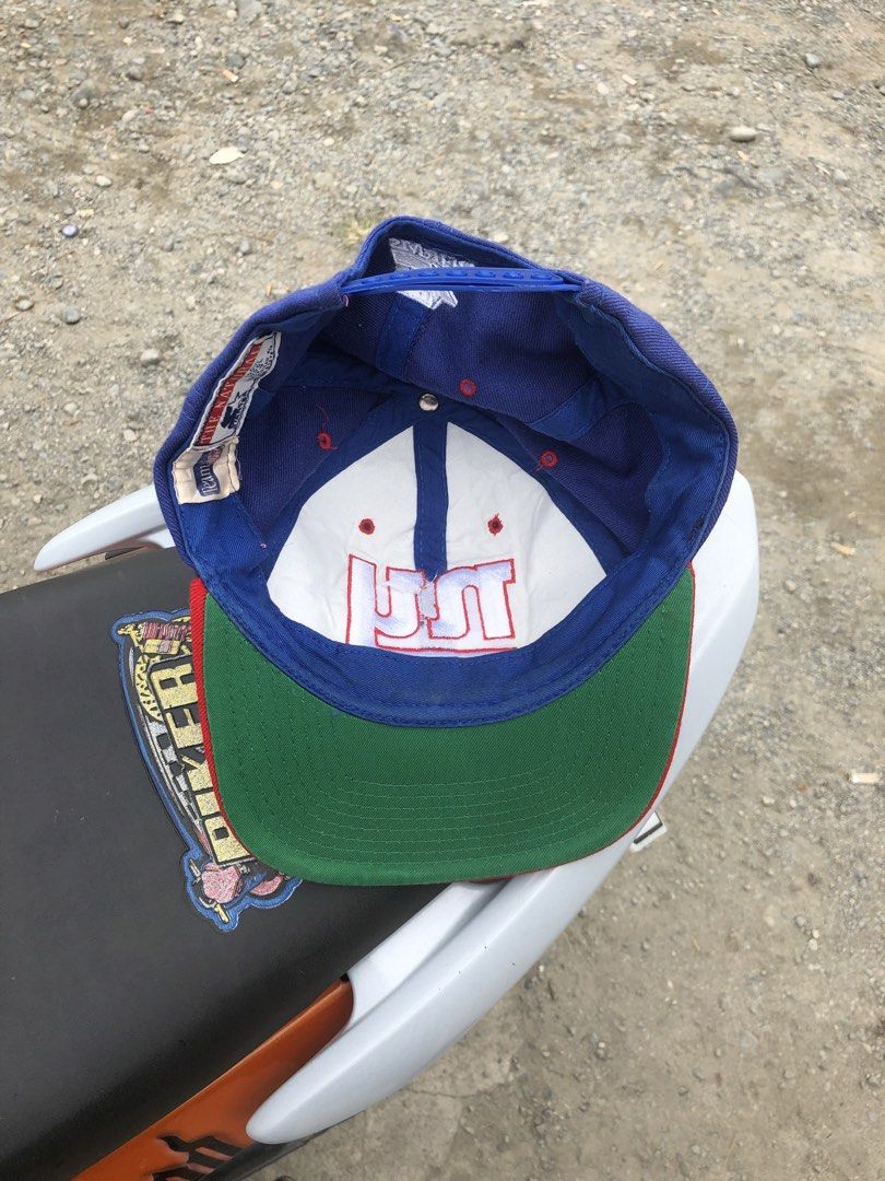 Starter New York Giants NFL Snapback Cap (Category: Caps & Hats) located in Montevista. Submitted by rdthriftshub (Listing ID 1462327173, Image 3). Description: - Classic blue and red New York Giants snapback cap - Iconic 'NY' logo embroidered on the front - Made by Starter, 100% wool - Green underside of the brim - Adjustable snapback closure for a comfortable fit - Perfect for any Giants fan.