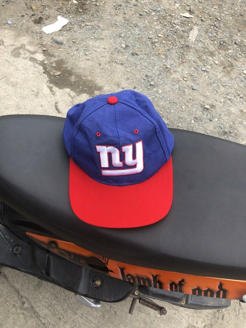 Starter New York Giants NFL Snapback Cap (Category: Caps & Hats) located in Montevista. Submitted by rdthriftshub (Listing ID 1462327173, Image 1). Description: - Classic blue and red New York Giants snapback cap - Iconic 'NY' logo embroidered on the front - Made by Starter, 100% wool - Green underside of the brim - Adjustable snapback closure for a comfortable fit - Perfect for any Giants fan.