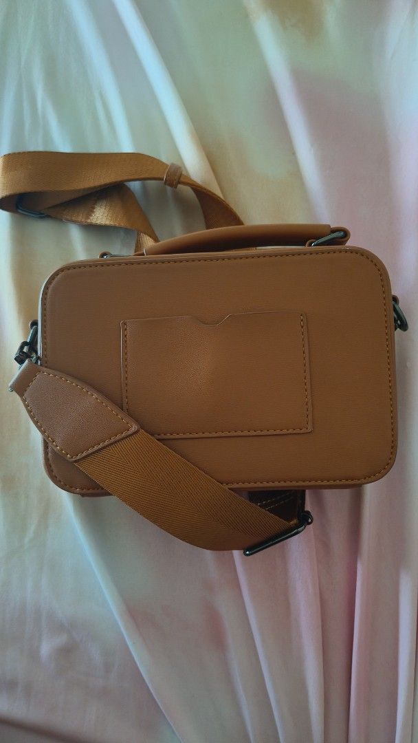 Straightforward Brown Leather Crossbody Bag with Strap (Category: Cross-body Bags) located in Manila. Submitted by eliana_marie (Listing ID 1462262353, Image 2). Description: Brown crossbody bag. Has a top handle and a long adjustable strap. Main compartment zips open. Back has a card slot. Simple and functional design. Great for everyday use..