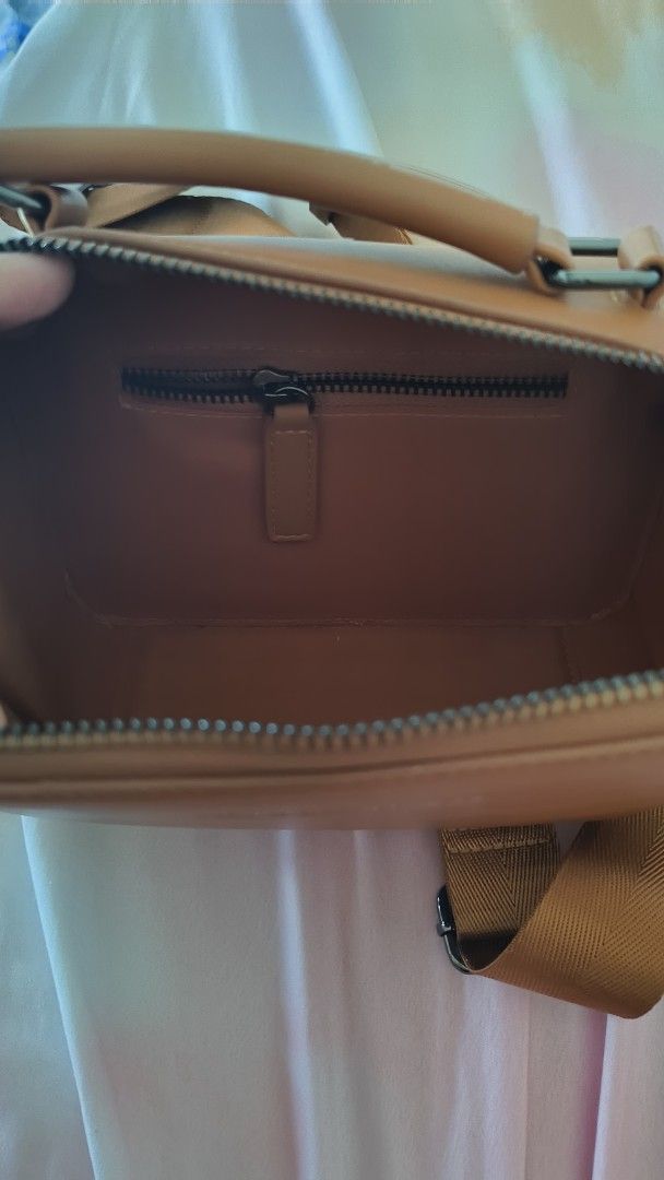 Straightforward Brown Leather Crossbody Bag with Strap (Category: Cross-body Bags) located in Manila. Submitted by eliana_marie (Listing ID 1462262353, Image 3). Description: Brown crossbody bag. Has a top handle and a long adjustable strap. Main compartment zips open. Back has a card slot. Simple and functional design. Great for everyday use..