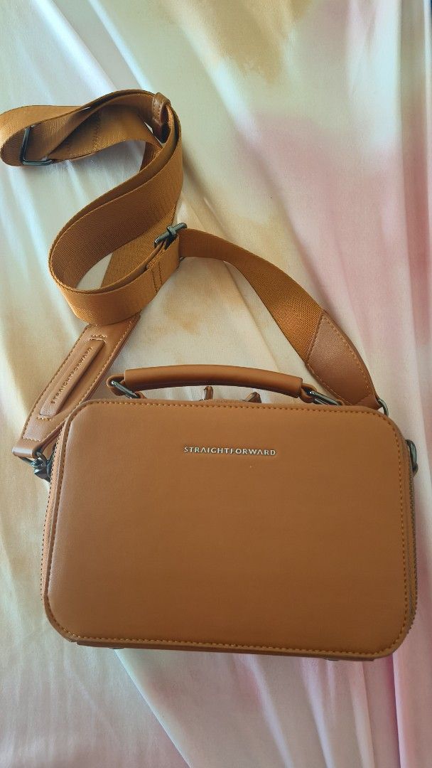 Straightforward Brown Leather Crossbody Bag with Strap (Category: Cross-body Bags) located in Manila. Submitted by eliana_marie (Listing ID 1462262353, Image 1). Description: Brown crossbody bag. Has a top handle and a long adjustable strap. Main compartment zips open. Back has a card slot. Simple and functional design. Great for everyday use..