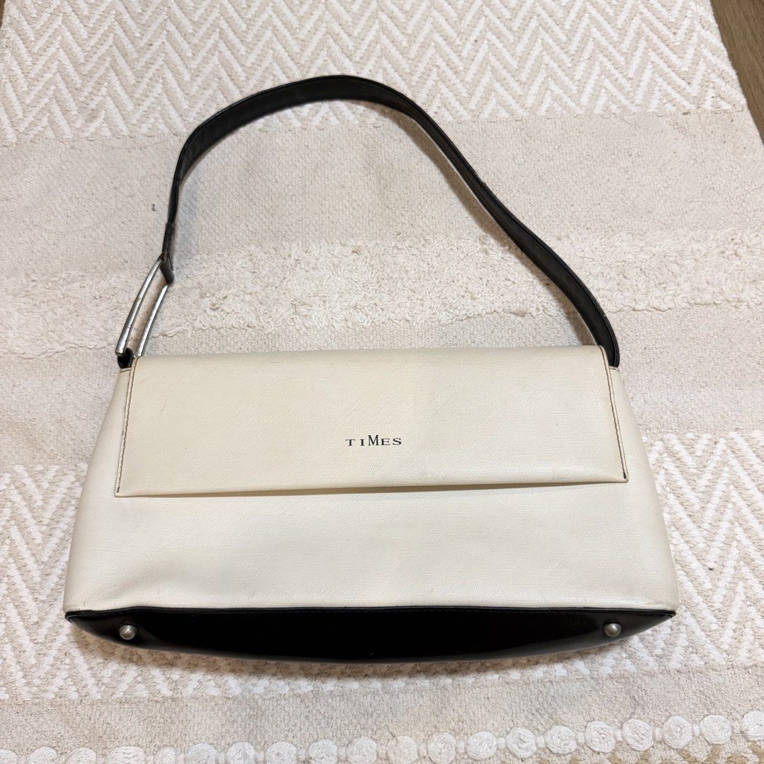 TIMES Cream and Black Shoulder Bag (Category: Shoulder Bags) located in Batangas. Submitted by prelove.kk (Listing ID 1462402730, Image 1). Description: - Cream and black shoulder bag by TIMES - Magnetic snap closure - Interior: 1 zippered pocket, 1 slip pocket - Tan colored lining - Black strap with silver buckle detail - Minor scuffs on the black bottom part - Interior is clean.