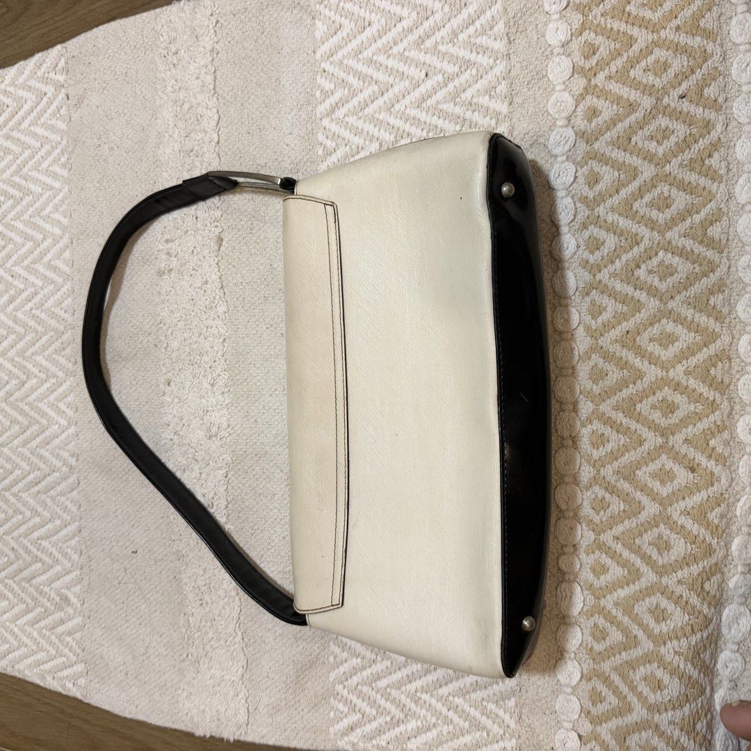 TIMES Cream and Black Shoulder Bag (Category: Shoulder Bags) located in Batangas. Submitted by prelove.kk (Listing ID 1462402730, Image 3). Description: - Cream and black shoulder bag by TIMES - Magnetic snap closure - Interior: 1 zippered pocket, 1 slip pocket - Tan colored lining - Black strap with silver buckle detail - Minor scuffs on the black bottom part - Interior is clean.