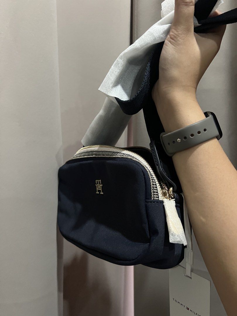Tommy Hilfiger Poppy Camera Bag Navy (Category: Cross-body Bags) located in Baliuag. Submitted by shop.avg (Listing ID 1462314720, Image 2). Description: - Navy blue Tommy Hilfiger crossbody bag - Features gold hardware and zip closure - Adjustable strap for comfortable wear - Brand new with original tags attached - Ideal for everyday use or travel - Spacious interior to hold your essentials.