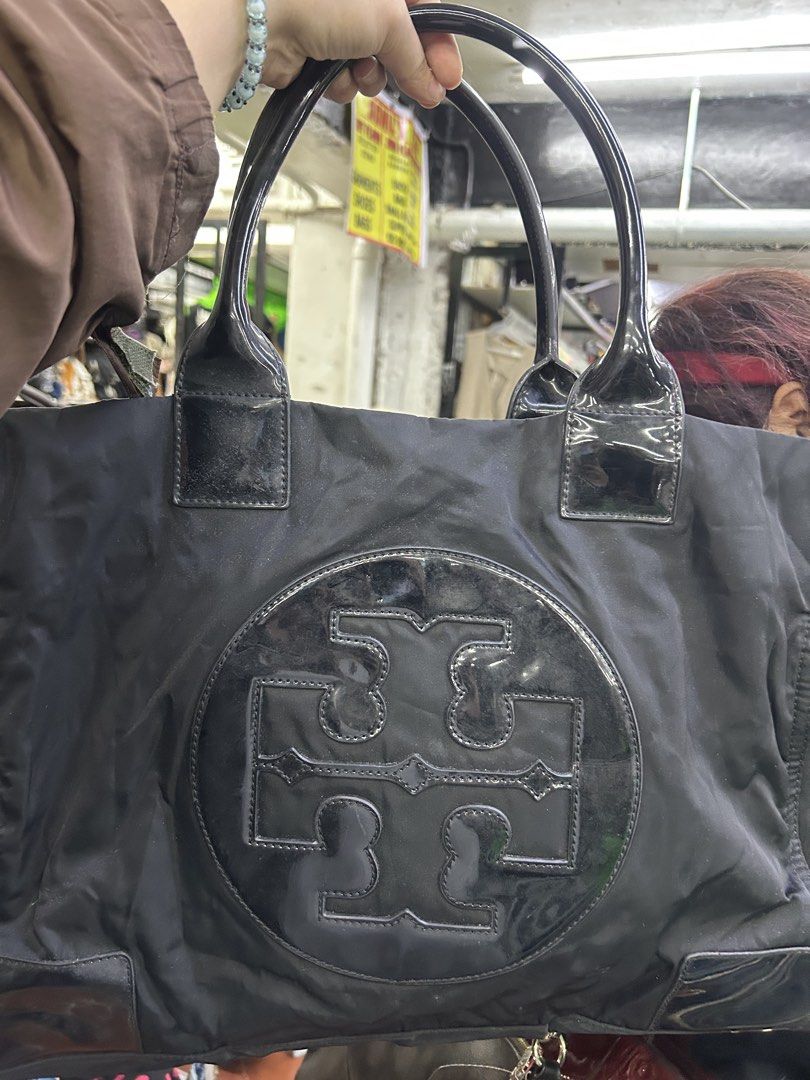 Tory Burch Black Nylon Tote Bag (Category: Tote Bags) located in Balanga. Submitted by coolwhale-76ba (Listing ID 1462406609, Image 1). Description: - Classic black Tory Burch tote bag - Made with durable nylon and patent leather accents - Spacious interior with a zippered pocket - Iconic Tory Burch logo on the front - Shiny patent leather handles - Great for everyday use or travel.