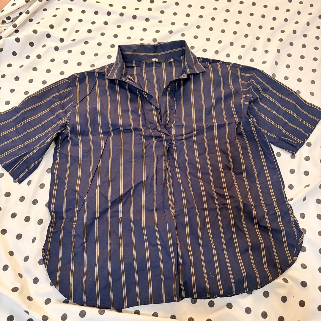 Uniqlo Navy Striped Collared Shirt (Category: Shirts) located in Pasay City. Submitted by notellyyyy (Listing ID 1462279311, Image 1). Description: - Navy blue shirt with subtle thin gold stripes - Short sleeves and a classic collared neckline - V-neck opening with a convenient button closure - Relaxed fit for ultimate comfort - Ideal for everyday casual wear.