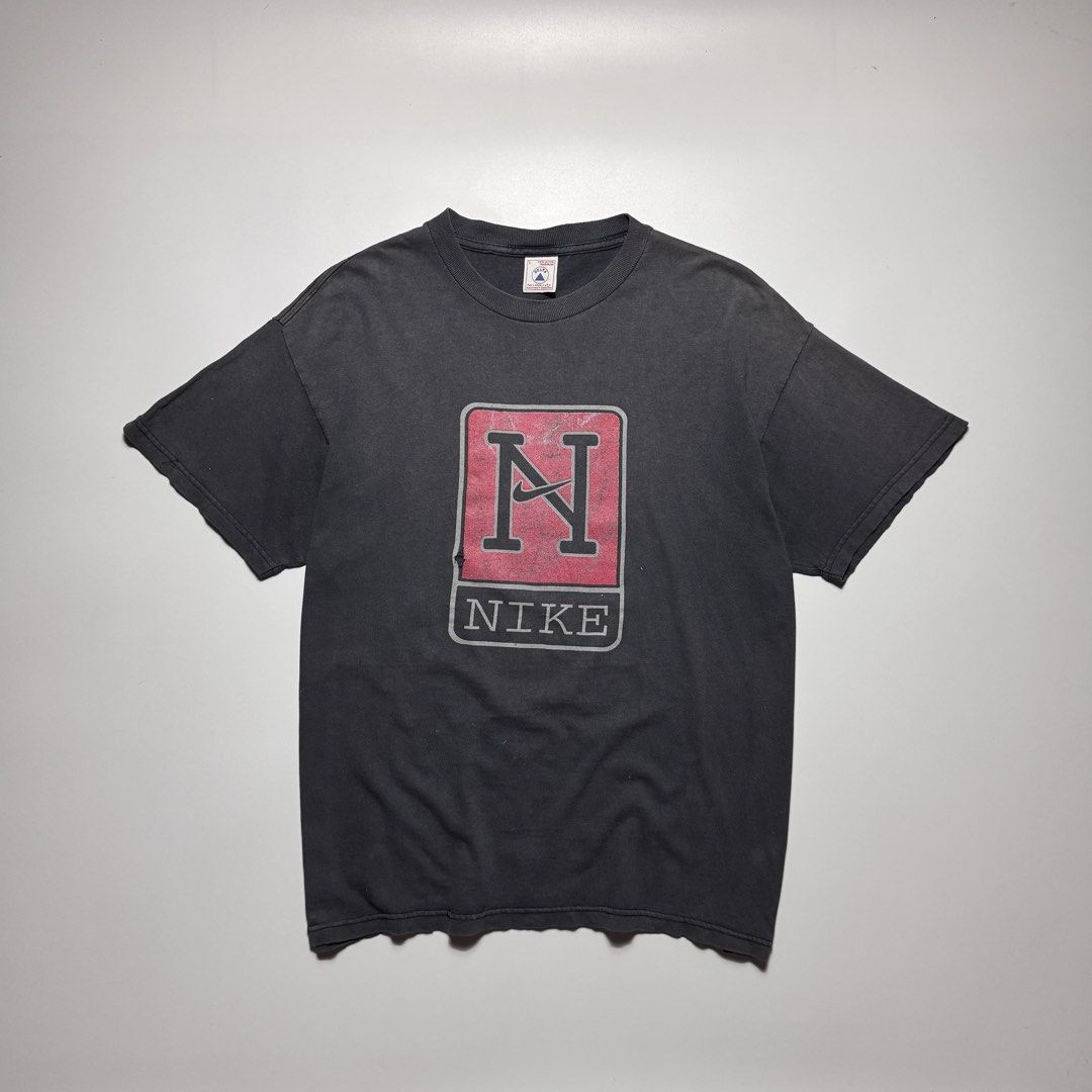 VINTAGE 1990s NIKE FADED TEE (Category: Tshirts & Polo Shirts ) located in Cebu City. Submitted by firenzegallery (Listing ID 1462425516, Image 1). Description: - Vintage Nike T-shirt - Features classic 'N' logo graphic - Faded, worn-in vintage look - Small tear present on the graphic - Ideal for Nike collectors and vintage enthusiasts.