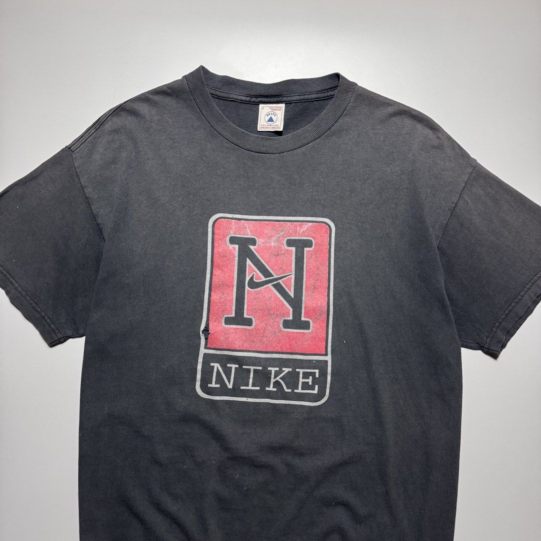 VINTAGE 1990s NIKE FADED TEE (Category: Tshirts & Polo Shirts ) located in Cebu City. Submitted by firenzegallery (Listing ID 1462425516, Image 2). Description: - Vintage Nike T-shirt - Features classic 'N' logo graphic - Faded, worn-in vintage look - Small tear present on the graphic - Ideal for Nike collectors and vintage enthusiasts.