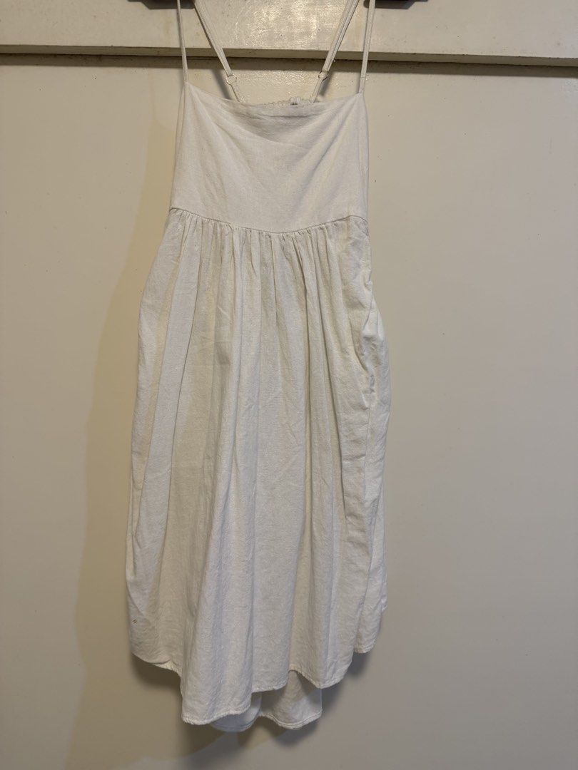 White Linen Blend Spaghetti Strap Midi Dress with Pockets (Category: Dresses) located in Antipolo. Submitted by elmclothing (Listing ID 1462398268, Image 2). Description: - White midi dress - Spaghetti straps with adjustable sliders - Gathered waistline with a flowy skirt - Convenient side pockets - Open back with elegant ruched detail - Lightweight fabric, ideal for hot weather - Versatile for casual or dressed-up occasions.
