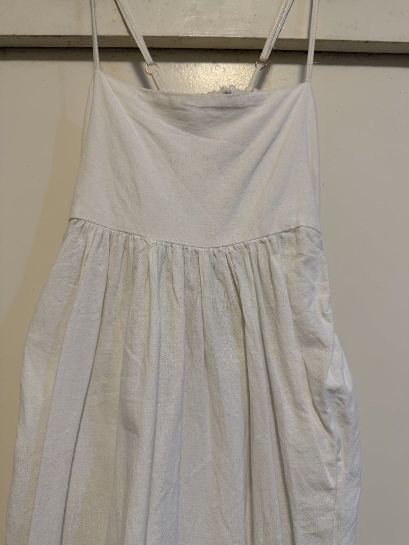 White Linen Blend Spaghetti Strap Midi Dress with Pockets (Category: Dresses) located in Antipolo. Submitted by elmclothing (Listing ID 1462398268, Image 1). Description: - White midi dress - Spaghetti straps with adjustable sliders - Gathered waistline with a flowy skirt - Convenient side pockets - Open back with elegant ruched detail - Lightweight fabric, ideal for hot weather - Versatile for casual or dressed-up occasions.