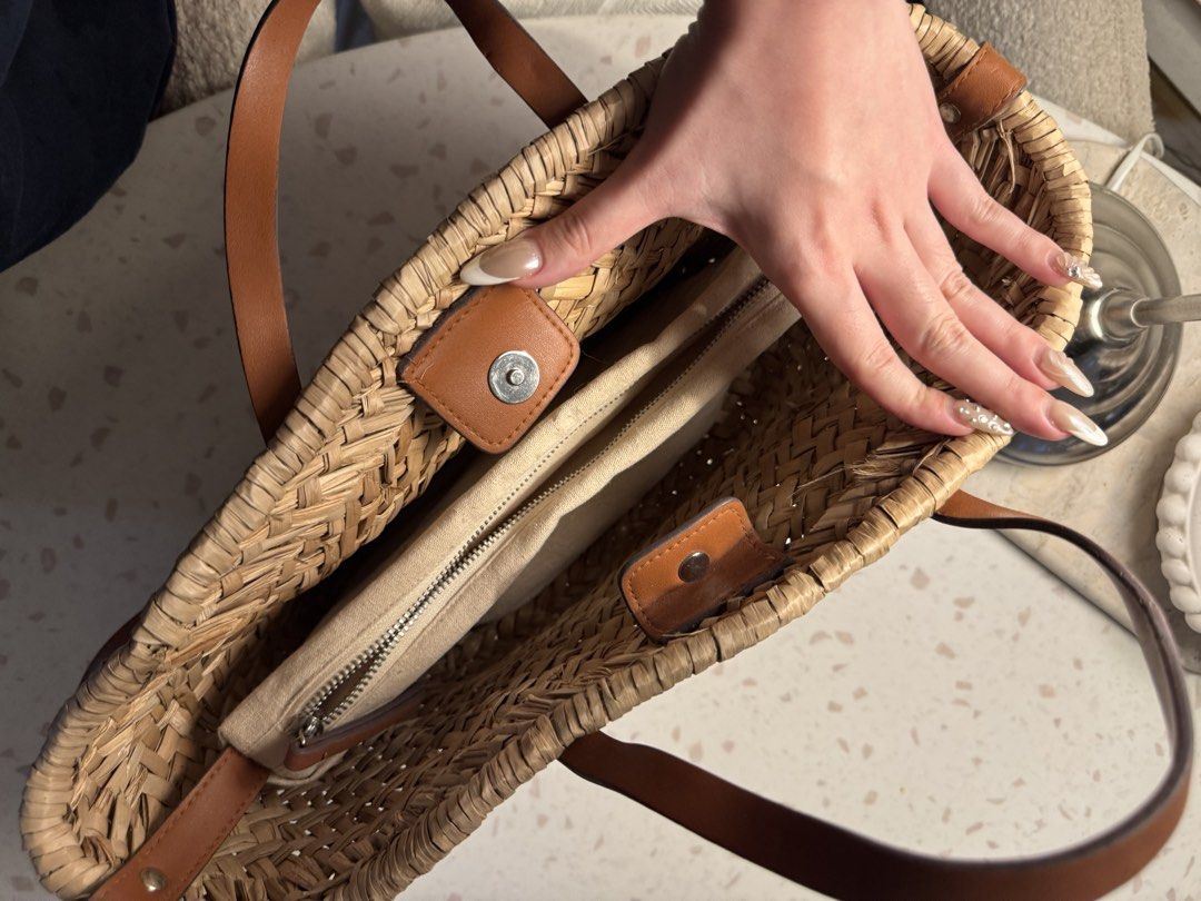 Woven Straw Tote Bag with Leather Handles (Category: Tote Bags) located in Las Pinas. Submitted by patringcia_14 (Listing ID 1462329800, Image 2). Description: - Cute woven straw tote bag - Natural straw color with brown leather accents - Zippered inner pouch for essentials - Magnetic snap closure - Top handles - Detachable shoulder strap - Ideal for beach days or everyday errands - Spacious enough for daily necessities.