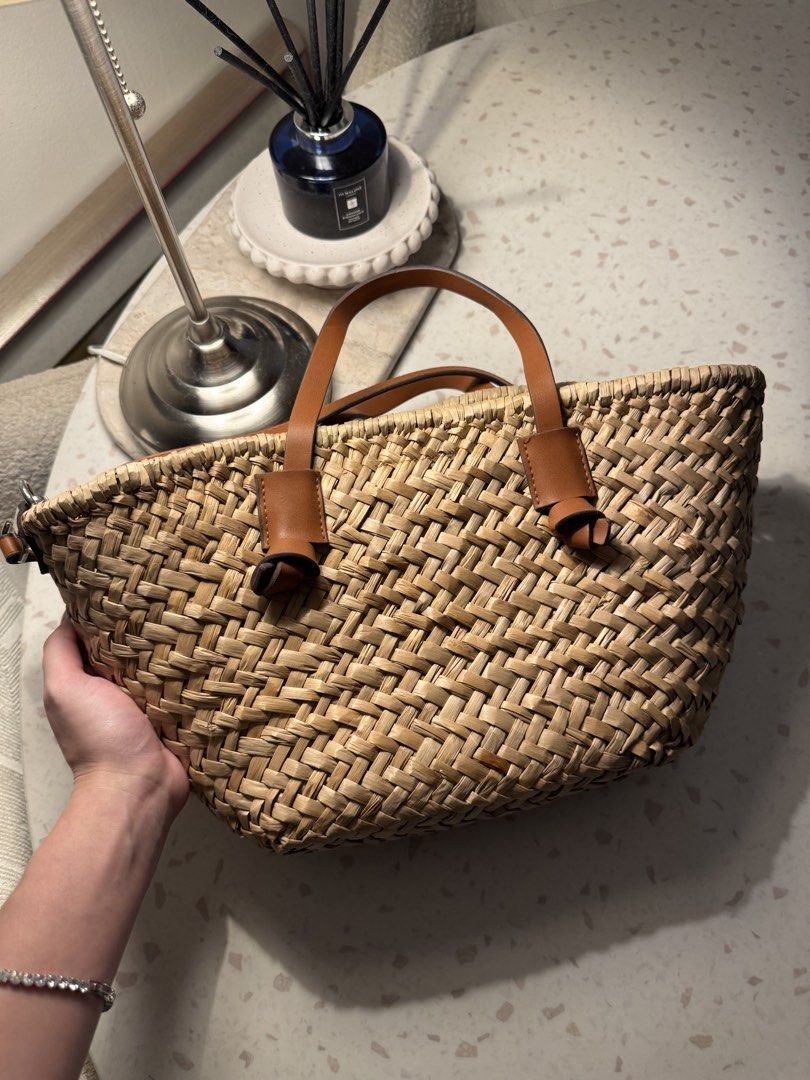 Woven Straw Tote Bag with Leather Handles (Category: Tote Bags) located in Las Pinas. Submitted by patringcia_14 (Listing ID 1462329800, Image 1). Description: - Cute woven straw tote bag - Natural straw color with brown leather accents - Zippered inner pouch for essentials - Magnetic snap closure - Top handles - Detachable shoulder strap - Ideal for beach days or everyday errands - Spacious enough for daily necessities.