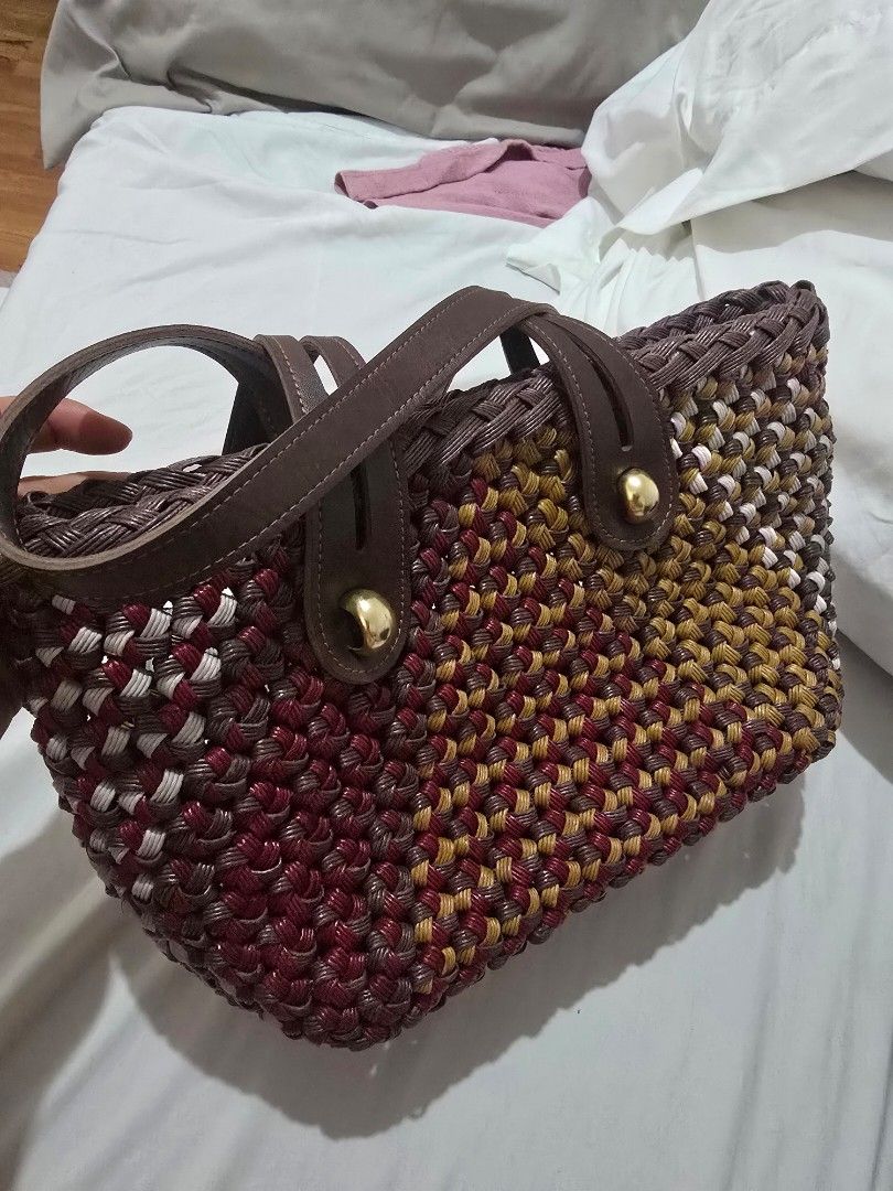 Woven Tote Bag with Leather Straps (Category: Tote Bags) located in Mandaluyong City. Submitted by mariasdesire (Listing ID 1462297467, Image 1). Description: - Unique woven tote bag - Features maroon, gold, and white threads in a distinctive pattern - Comfortable brown leather straps - Elegant gold button details - Interior also has a woven pattern - Ideal for everyday use or beach outings - Spacious enough to carry your essentials.