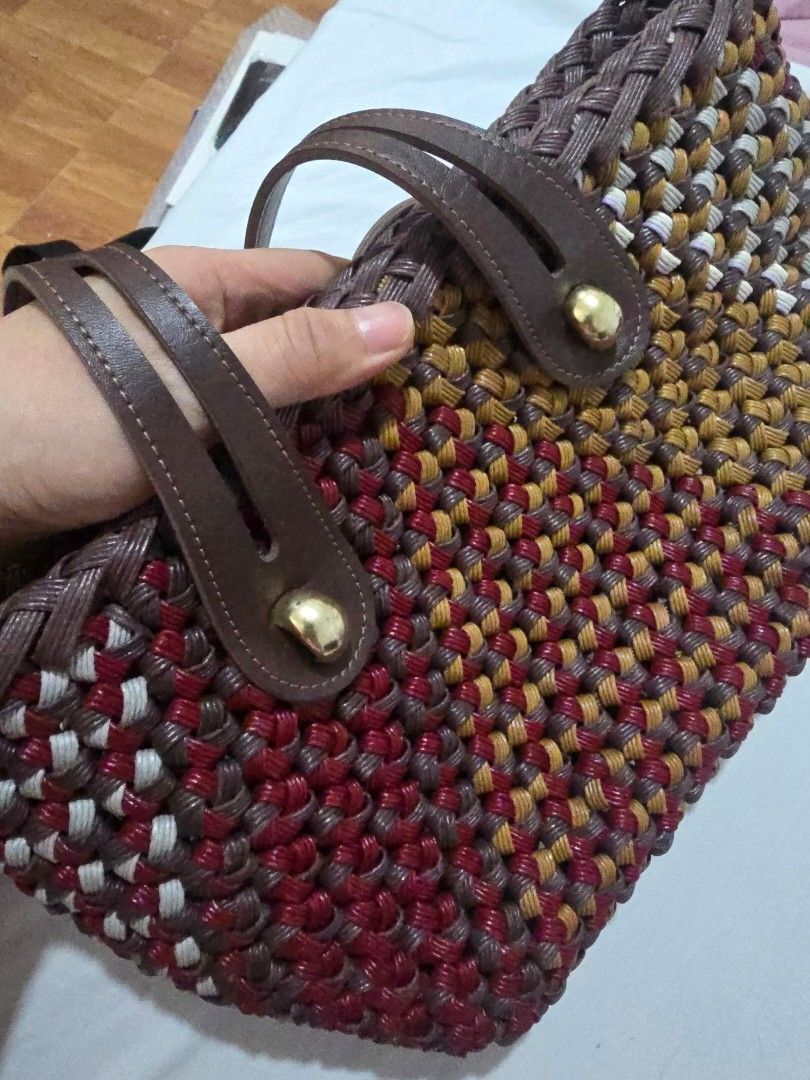 Woven Tote Bag with Leather Straps (Category: Tote Bags) located in Mandaluyong City. Submitted by mariasdesire (Listing ID 1462297467, Image 3). Description: - Unique woven tote bag - Features maroon, gold, and white threads in a distinctive pattern - Comfortable brown leather straps - Elegant gold button details - Interior also has a woven pattern - Ideal for everyday use or beach outings - Spacious enough to carry your essentials.