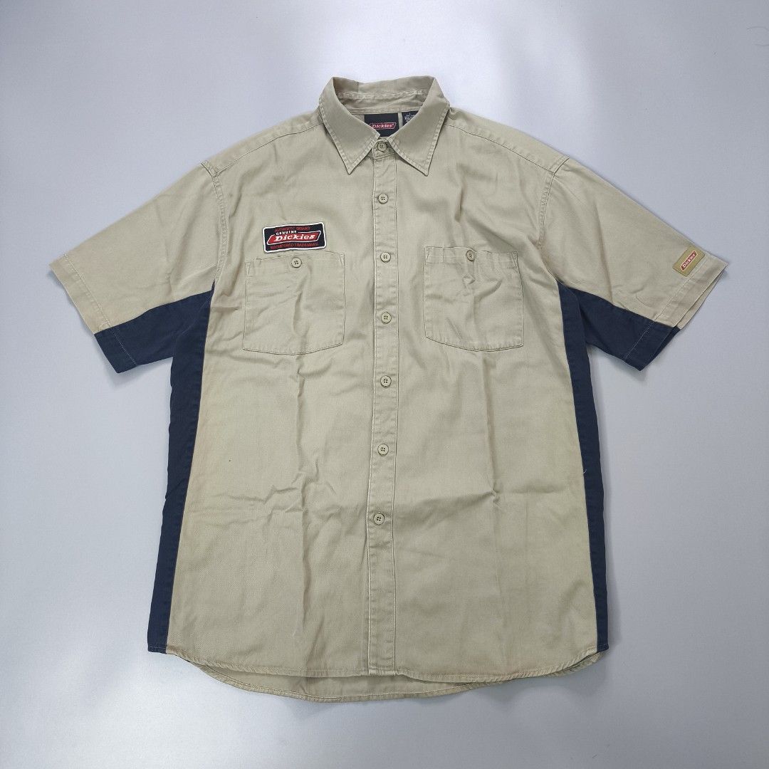 Y2k Dickies Short Sleeve Work Shirt (Category: Tshirts & Polo Shirts ) located in Calamba. Submitted by adi_thrift (Listing ID 1462422154, Image 1). Description: - Dickies Work Shirt - Width 24 / Length 29.5 - Color: Tan with Navy Blue Side Panels - Sleeve Length: Short Sleeves - Closure: Button-up Front - Pockets: Two Chest Pockets - Branding: Classic Dickies Logo Patch on Chest & Sleeve Tag - Size: Large (L) - Material: 100% Cotton.
