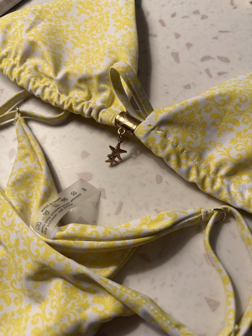 Yellow Baroque Print Bikini Set with Starfish Charm (Category: Bikinis & Swimsuits) located in Las Pinas. Submitted by patringcia_14 (Listing ID 1462322773, Image 3). Description: - Cute yellow bikini with a stylish baroque-inspired print. - Features adjustable tie straps for a perfect fit. - Adorned with a delicate gold-tone starfish charm on the front. - Bikini bottoms have trendy ruched detailing on the sides. - Ideal for beach days and pool p