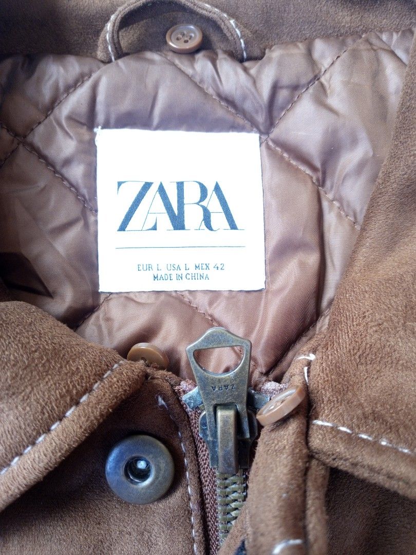 Zara Brown Suede-like Trucker Jacket (Category: Coats, Jackets and Outerwear) located in Liloan. Submitted by dnznoon31 (Listing ID 1462377274, Image 2). Description: - Zara brown trucker jacket - Suede-like material - Quilted lining for extra warmth - Button closure at front and cuffs - Two chest pockets with button closure - Side pockets - Size L - Dimensions 23 x 26 inches - Ideal for layering.