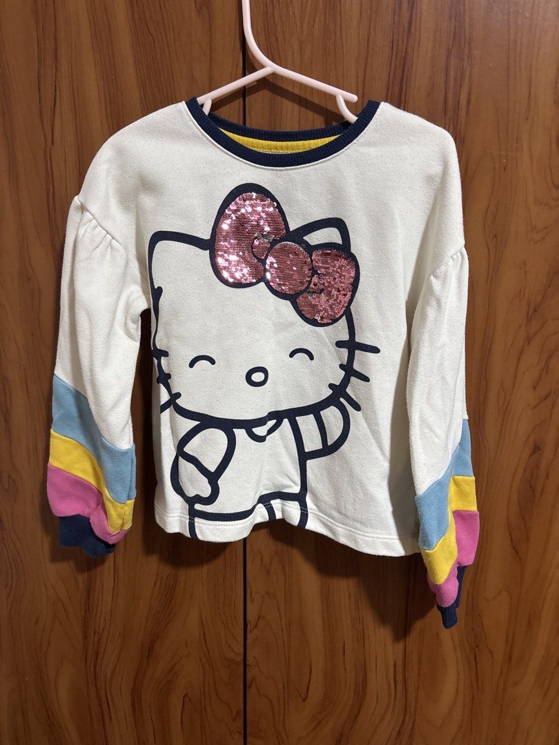 365 Kids x Hello Kitty Sequin Bow Sweatshirt (Category: Babies & Kids Fashion) located in Manila. Submitted by wardrobeinmnl (Listing ID 1462613881, Image 1). Description: SIZE: 5 - Adorable white sweatshirt featuring a large Kitty graphic. - Kitty's bow is adorned with sparkly pink sequins. - Sleeves boast colorful stripes in blue, yellow, pink, and navy blue cuffs. - Made from a soft, comfortable fabric. - Ideal for casual wear and a must-have 