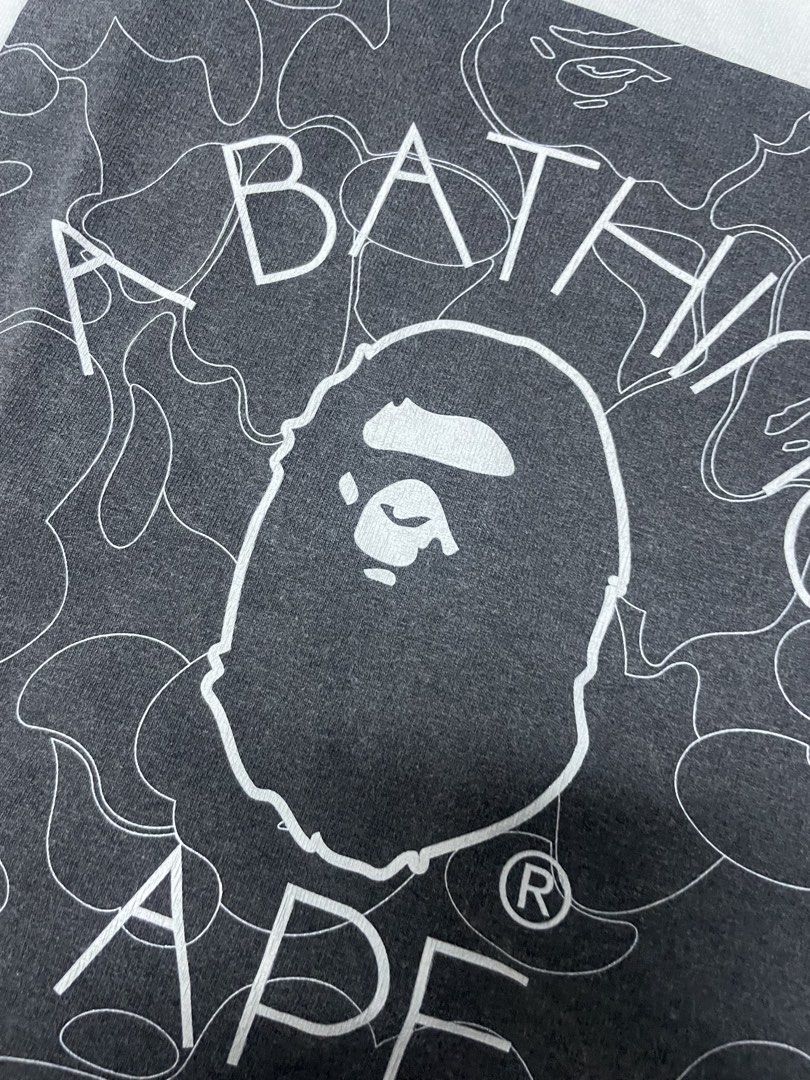 A Bathing Ape BAPE Tee White (Category: Tshirts & Polo Shirts ) located in Manila. Submitted by yourfavoriteplug (Listing ID 1462508440, Image 3). Description: - White BAPE T-shirt - Classic ape head logo graphic - Signature camo pattern in background - Tagged size Medium - Essential for any streetwear collection.