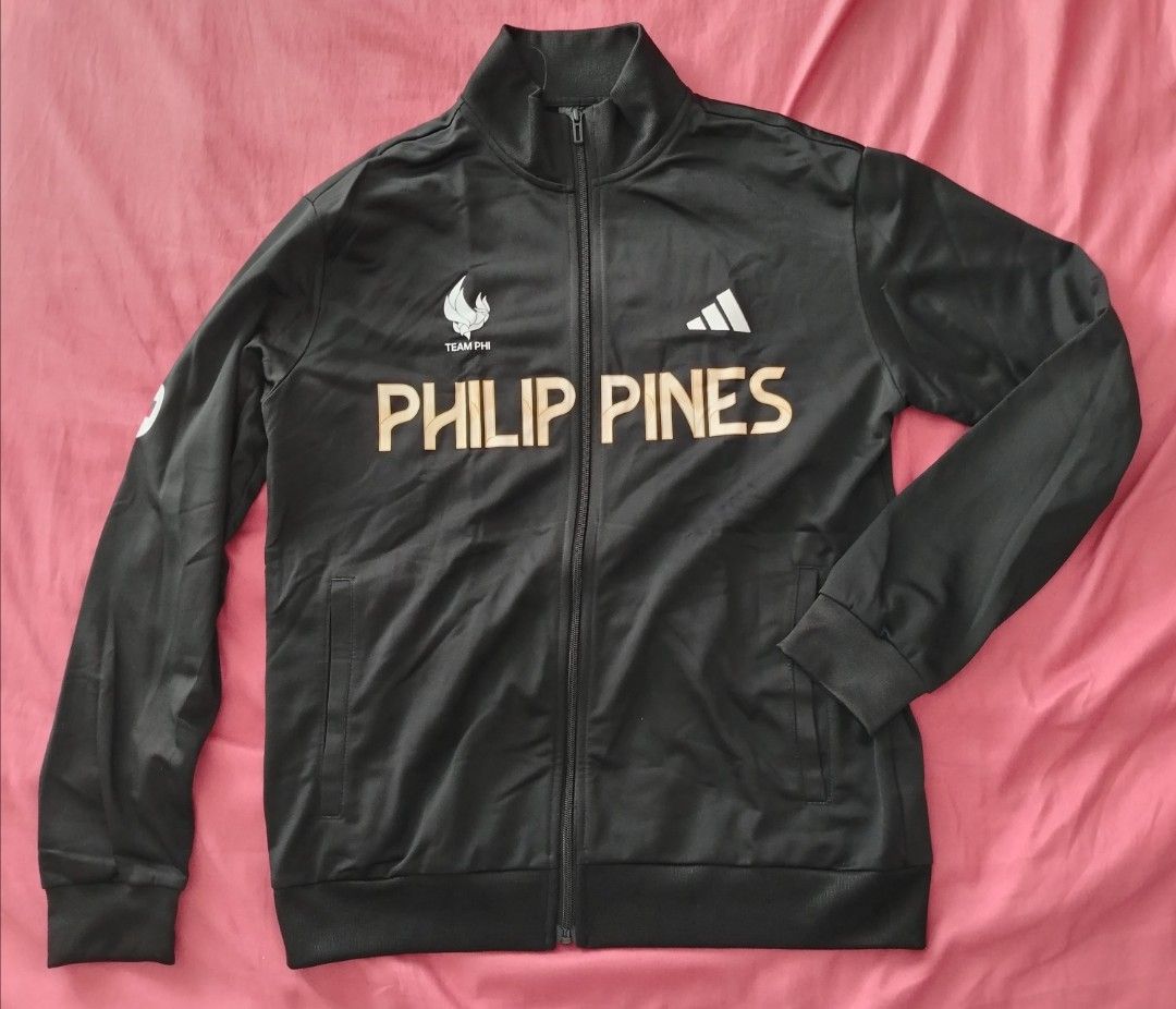 Adidas Team Philippines Track Jacket and Pants Set (Category: Activewear) located in Quezon City. Submitted by gabbys_closet16 (Listing ID 1462456418, Image 1). Description: - Authentic Adidas tracksuit set for Team Philippines. - Size : Large - Color: Black with gold accents. - Jacket features 'PHILIPPINES' text and national emblem on the back. - Track pants have the iconic Adidas logo. - Brand new with tags still attached. - Original price : 46