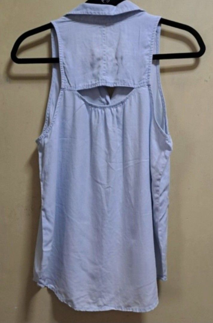 American Eagle Sleeveless Polo Blouse (Category: Sleeveless) located in Manila. Submitted by thrifter_lifestyle (Listing ID 1462600250, Image 2). Description: Brand: American Eagle (bought in US) Collared Sleeveless Button down with single pocket in front Back has cutout hole design (see photo) Bust: 40" Material: Cotton Actual Color: Very light washout blue No issues 😀 RFS: no longer fits me, no worn photos..