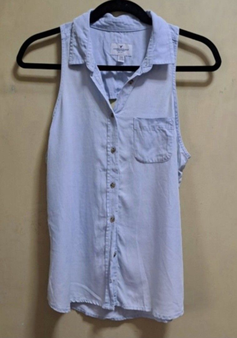 American Eagle Sleeveless Polo Blouse (Category: Sleeveless) located in Manila. Submitted by thrifter_lifestyle (Listing ID 1462600250, Image 1). Description: Brand: American Eagle (bought in US) Collared Sleeveless Button down with single pocket in front Back has cutout hole design (see photo) Bust: 40" Material: Cotton Actual Color: Very light washout blue No issues 😀 RFS: no longer fits me, no worn photos..