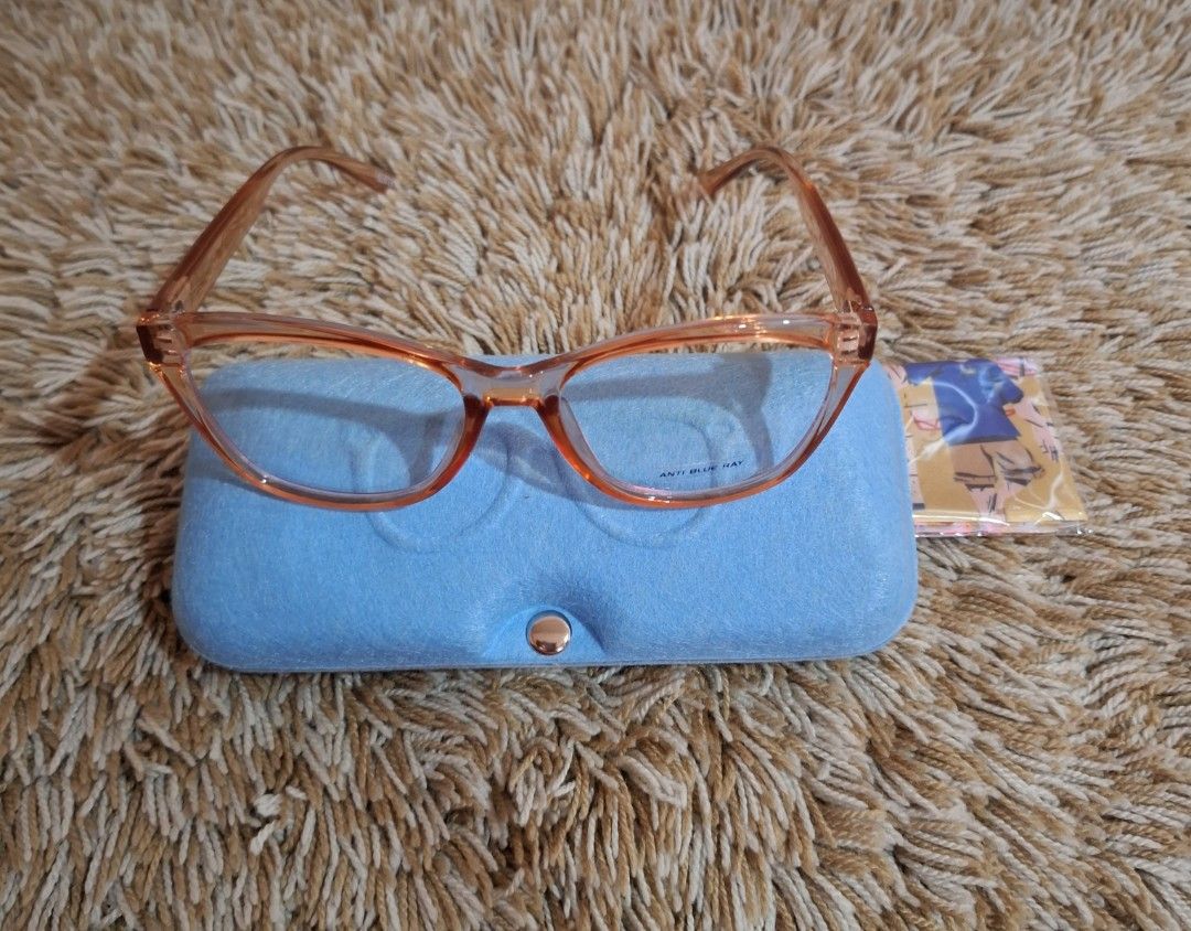 Antepara BT21 Eyeglasses (Category: Sunglasses & Eyewear) located in Rizal. Submitted by mirisica (Listing ID 1462568573, Image 1). Description: - Trendy orange cat-eye frames - Anti-blue light lenses for eye protection - Comes with a protective blue hard case - Includes a microfiber cleaning cloth - Adorable character designs on the arms - Ideal for daily computer use and gaming - Protect your eyes while looking stylish.