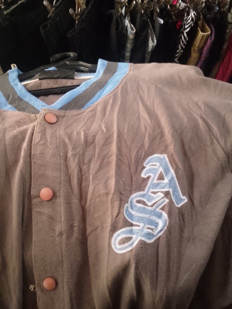 Apart Varsity Jacket Size L (Category: Coats, Jackets and Outerwear) located in Manila. Submitted by warmcloud-06f3 (Listing ID 1462555629, Image 1). Description: - Brand: Apart - Style: Brown Varsity Jacket - Size: L - Details: Blue and grey striped collar and cuffs - Chest: 'ASA' embroidery - Back: Graffiti-style design - Closure: Button-up front.