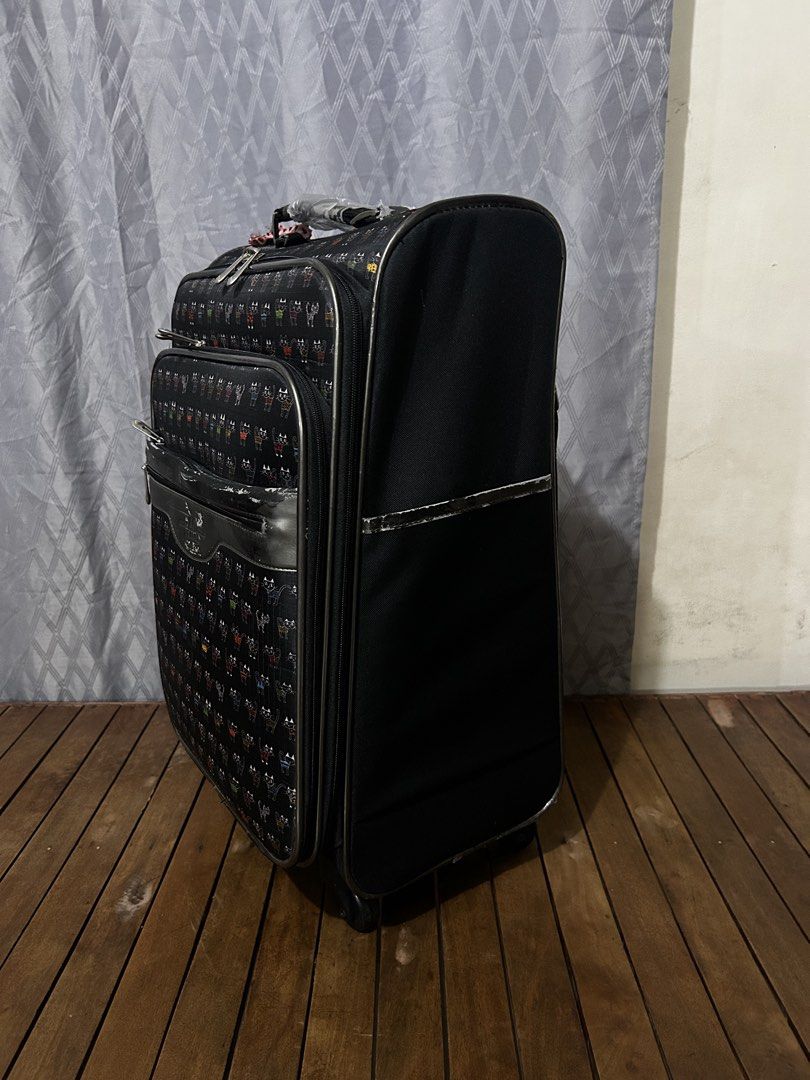 ATSUKI ONISHI (Category: Luggage) located in Taguig. Submitted by ghiebow06 (Listing ID 1462614071, Image 2). Description: with lock and key Dimensions: H- 22 1/2 W- 13 D- 8 Issue: scratches - Black rolling suitcase with a fun cartoon cat pattern. - Retractable handle and wheels for easy mobility. - Front zipper pocket for quick access to essentials. - Versatile for travel or everyday use..