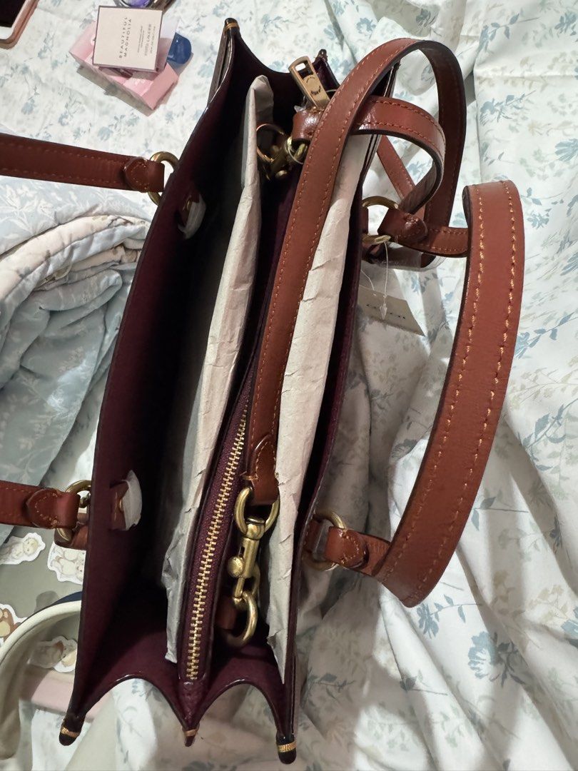 AUTHENTIC Coach Signature Tote Bag - B4/TAN RUST (Category: Luxury Bags & Wallets) located in Cainta. Submitted by trufflecake (Listing ID 1462467939, Image 3). Description: - Authentic Coach tote bag - Signature print in tan rust color - Genuine leather trim and handles - Interior zip pocket for essentials - Detachable strap for versatile carrying - Made in Indonesia - Brand new with tag still attached.