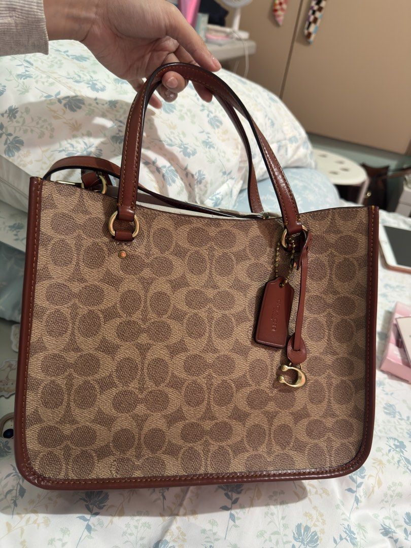 AUTHENTIC Coach Signature Tote Bag - B4/TAN RUST (Category: Luxury Bags & Wallets) located in Cainta. Submitted by trufflecake (Listing ID 1462467939, Image 1). Description: - Authentic Coach tote bag - Signature print in tan rust color - Genuine leather trim and handles - Interior zip pocket for essentials - Detachable strap for versatile carrying - Made in Indonesia - Brand new with tag still attached.