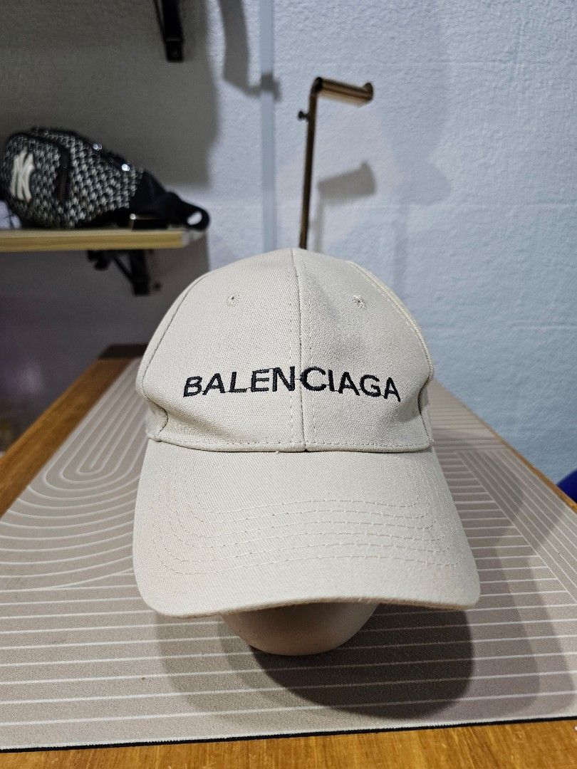 Balenciaga cotton baseball cap (Category: Caps & Hats) located in Baguio. Submitted by kayeonlineshop (Listing ID 1462550911, Image 1). Description: -beige Balenciaga cotton baseball cap featuring bold black embroidered lettering across the front panel.
