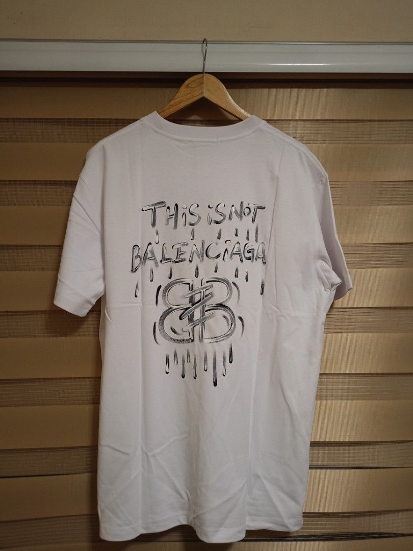 Balenciaga "This is Not" Shirt (Category: Luxury Apparel) located in Valenzuela. Submitted by One.Only.Nan (Listing ID 1462626517, Image 1). Description: XL on tag Actual W23" L30" Excellent condition 10 color rate MOP GCASH MAYA AUB BPI VALENZUELA CITY LOC.