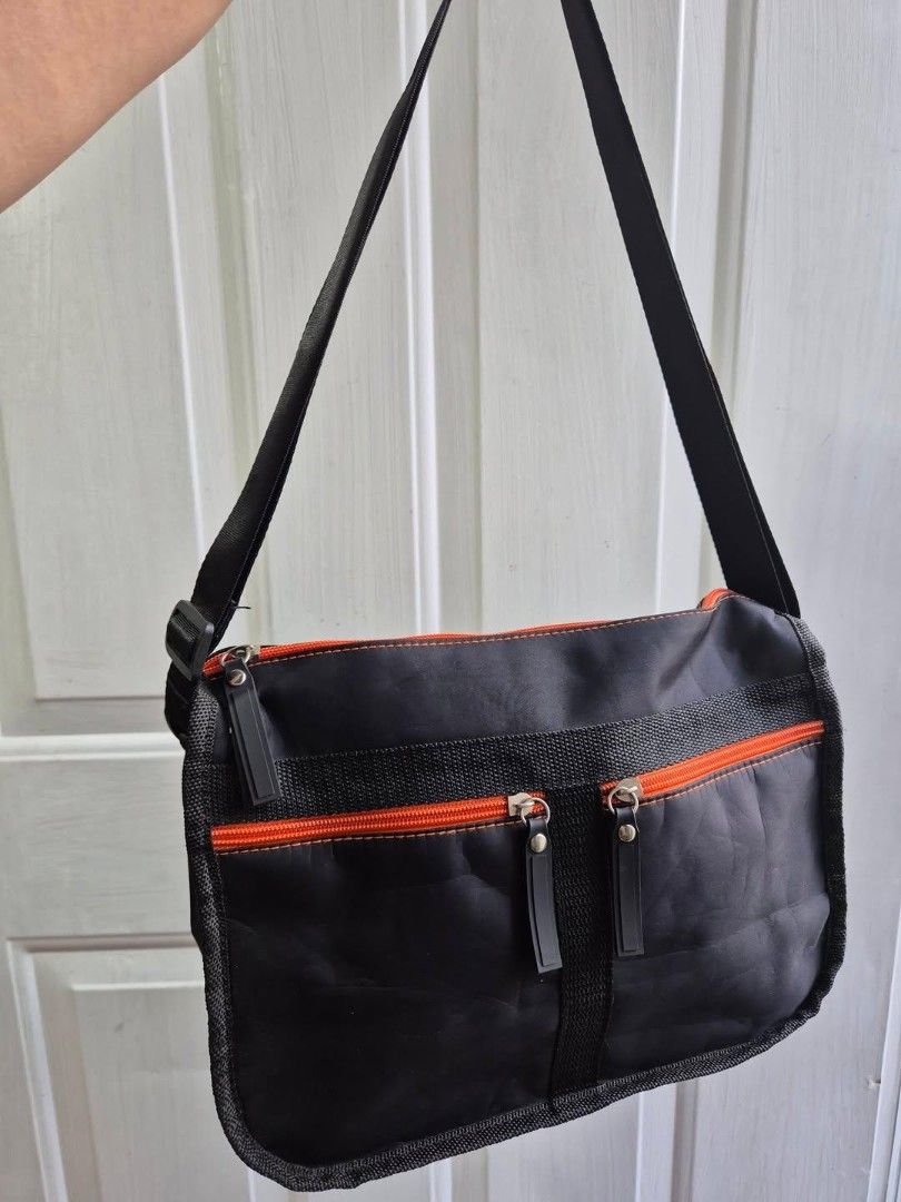 Black Messenger Bag with Orange Accents (Category: Luxury Bags & Wallets) located in Manila. Submitted by princessahshop (Listing ID 1462568694, Image 1). Description: No brand nylon sling ₱199 only + sf 🎀Color rate 9/10 🎀Issue dami sign of tupi 🎀Size Height 7 inches, length 11 inches, depth 5 inches.