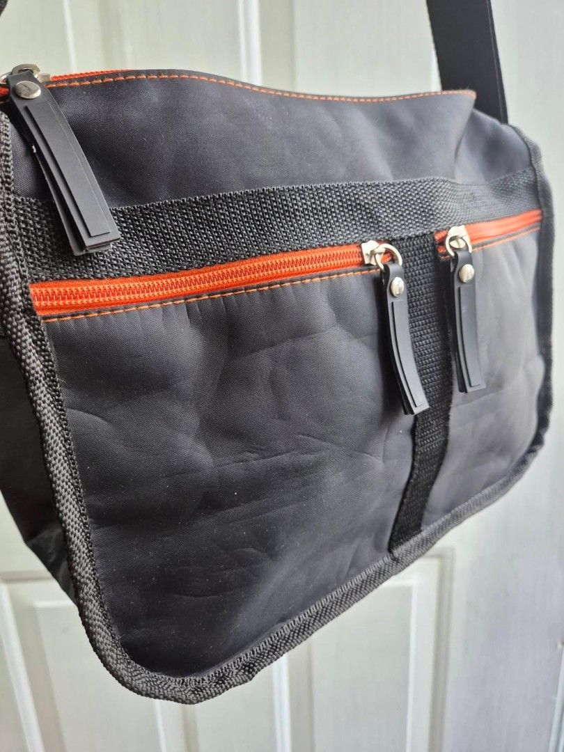 Black Messenger Bag with Orange Accents (Category: Luxury Bags & Wallets) located in Manila. Submitted by princessahshop (Listing ID 1462568694, Image 2). Description: No brand nylon sling ₱199 only + sf 🎀Color rate 9/10 🎀Issue dami sign of tupi 🎀Size Height 7 inches, length 11 inches, depth 5 inches.