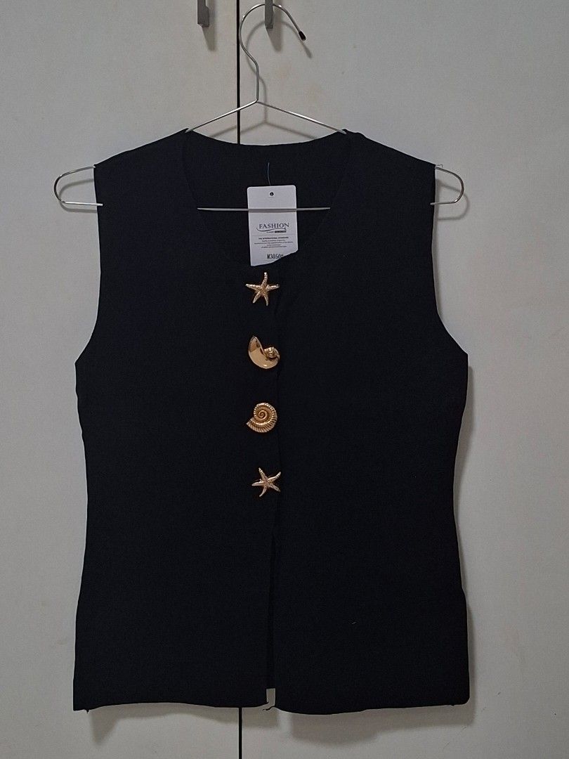 Black Sleeveless Knitted Vest (Category: Sleeveless) located in Manila. Submitted by preloved_tweeds_ph (Listing ID 1462615996, Image 1). Description: - Sleeveless black vest - Unique gold buttons (seashell & starfish design) - Ideal for layering - Versatile for casual or smart-casual outfits - Simple and chic style.