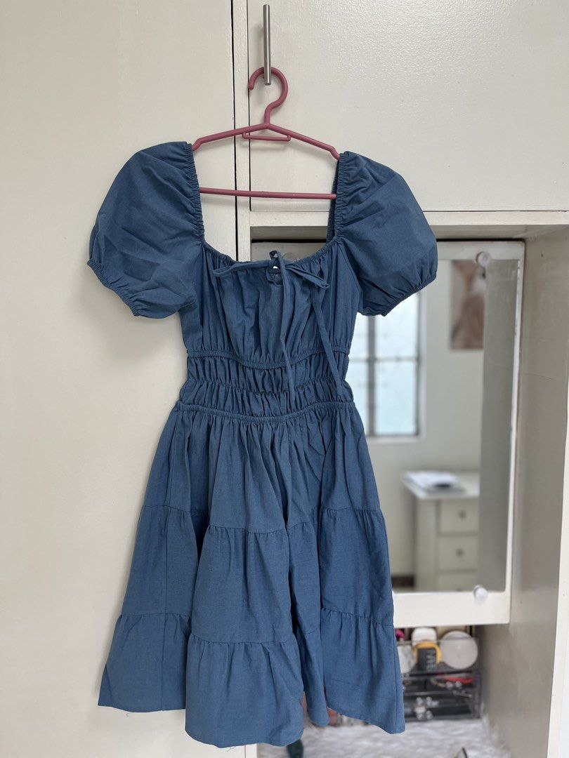 Blue Puff Sleeve Tiered Square Neck Dress (Category: Dresses) located in Caloocan City. Submitted by laleleigh (Listing ID 1462517841, Image 2). Description: - Dusty blue dress - Features puff sleeves and a square neckline - Smocked bodice for a comfortable fit - Tiered skirt for a playful look - Ties at the front for adjustable styling - Ideal for casual outings and everyday wear - MOP: Gcash/Bank transfer.